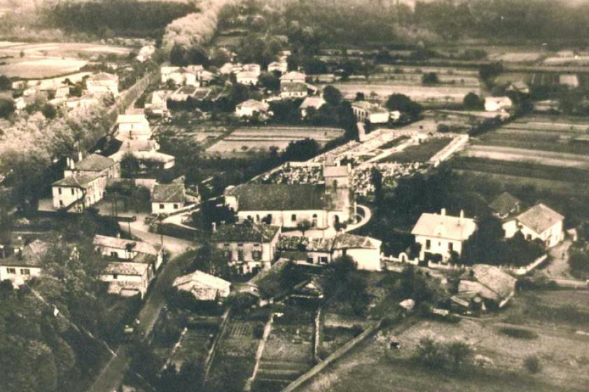  Église Saint Vincent et actuelle place Dous Haous au début des années 1950. Dans la partie supérieure gauche, la RD810 (ex RN10) bordée de platanes