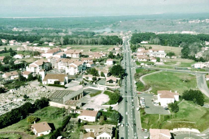Vue aérienne de 1998, direction Bayonne Ondres. A droite de la RD810, l'ancienne mairie, à gauche, la salle Jacques Duclos, le cimetière, l'église Saint Vincent et la place Dous Haous